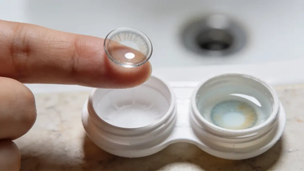 Microscopic crystalline deposits and bacteria risk inside an empty dried contact lens case from unreplaced solution.